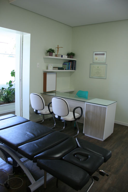 Mesa de avaliação e maca na sala do consultório