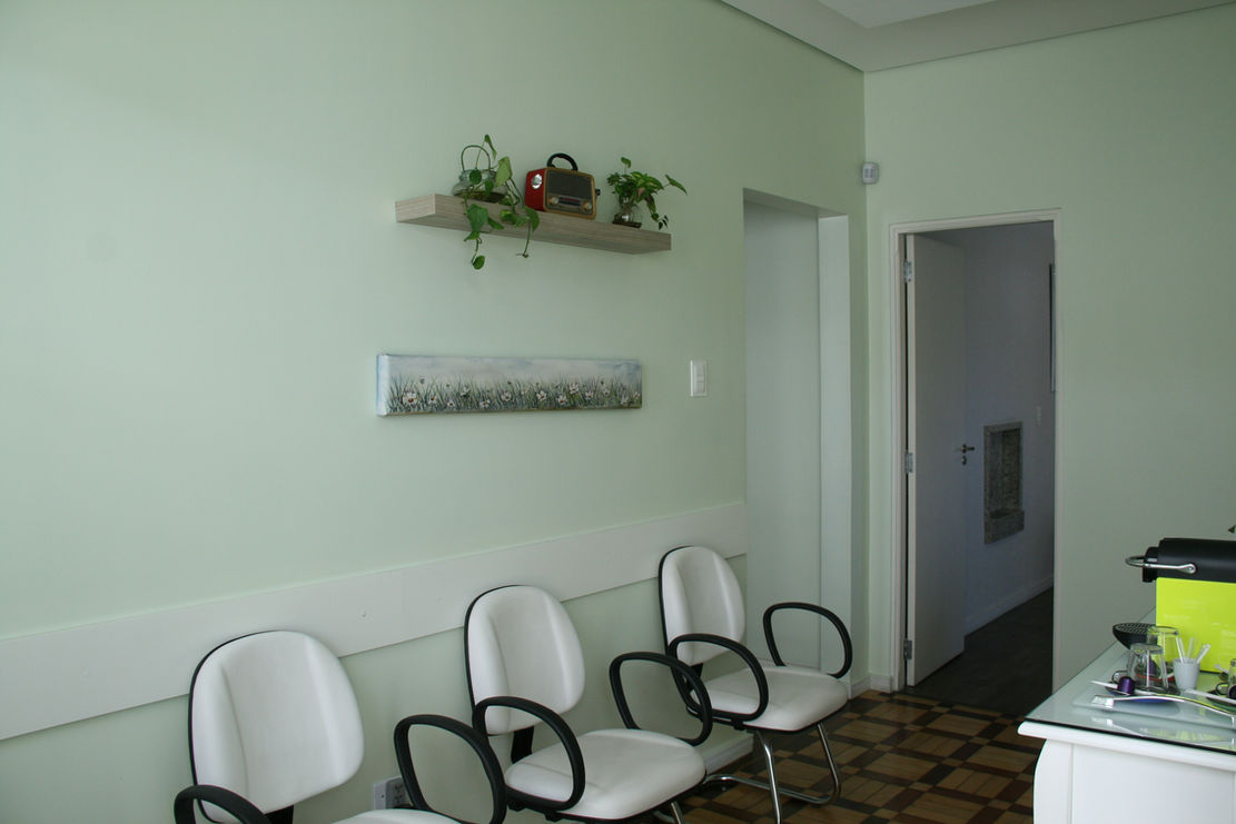 Recepção do consultório com cadeiras e paredes verde-claro